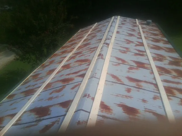 Rusted metal roof panels with new wood purlins before replacement — Storm Damage Roof Repair in Commack by Roofing Brothers
