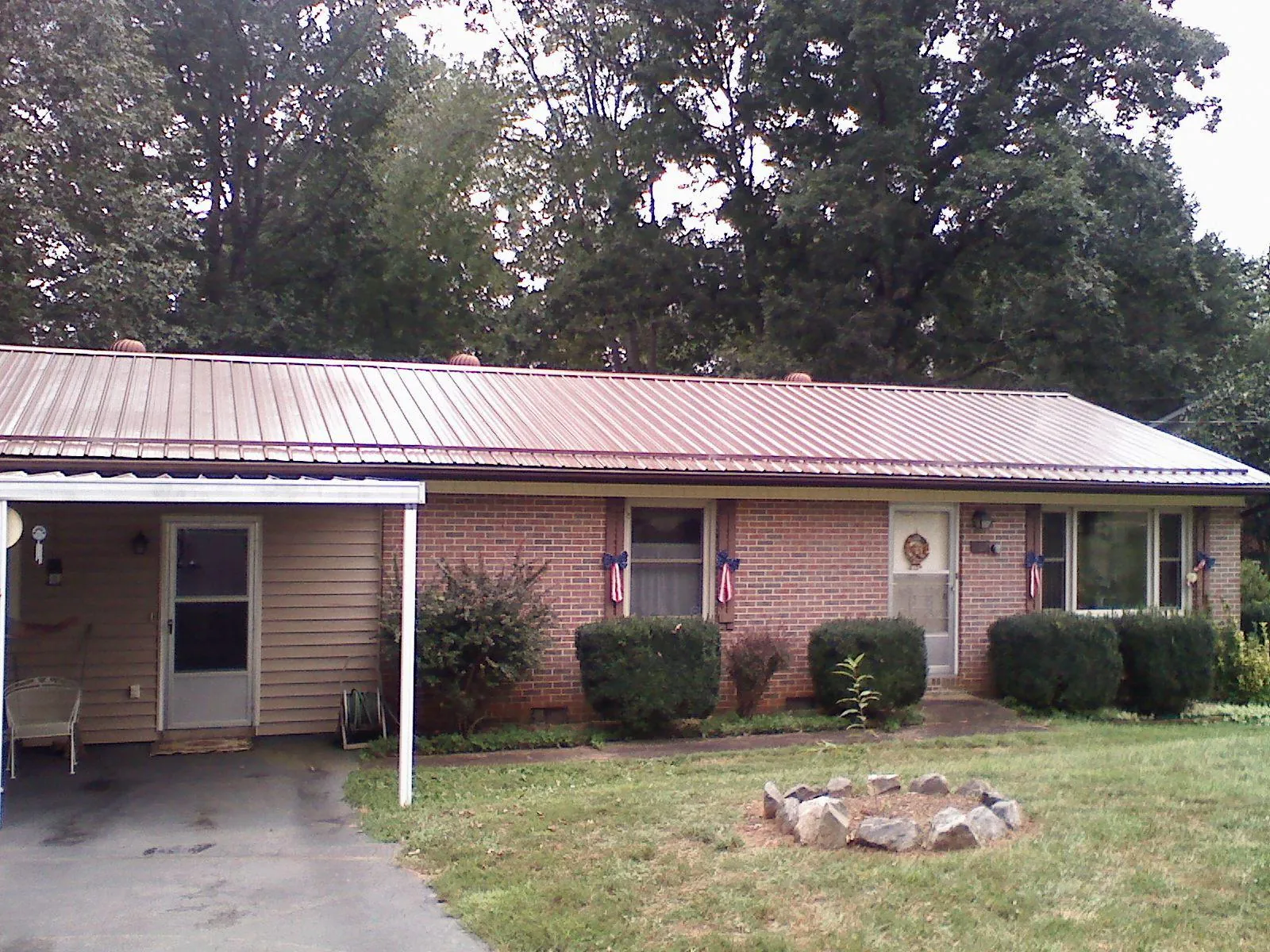 Bronze metal roof and carport on a brick ranch home — Roof Repair work by our crew in Commack