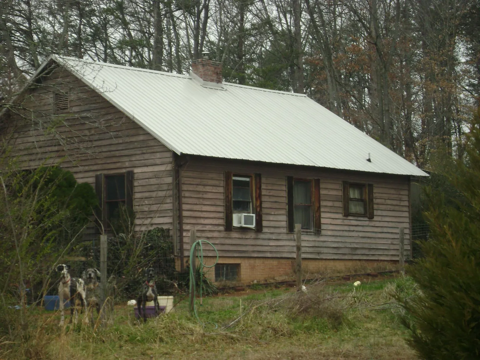 White metal roof on an old wood sided farmhouse, from a Metal Roof Installation job in Commack